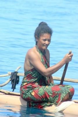 Lady Folling Heinrich on her cane canoe on the sea
